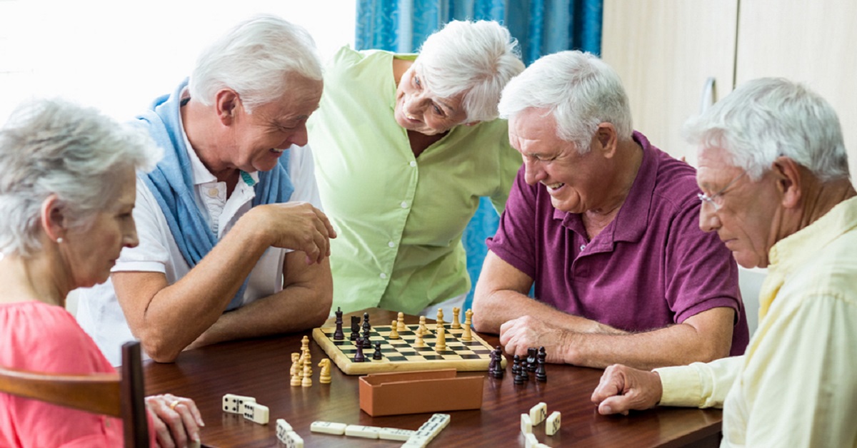 A group of elderly people play board games.